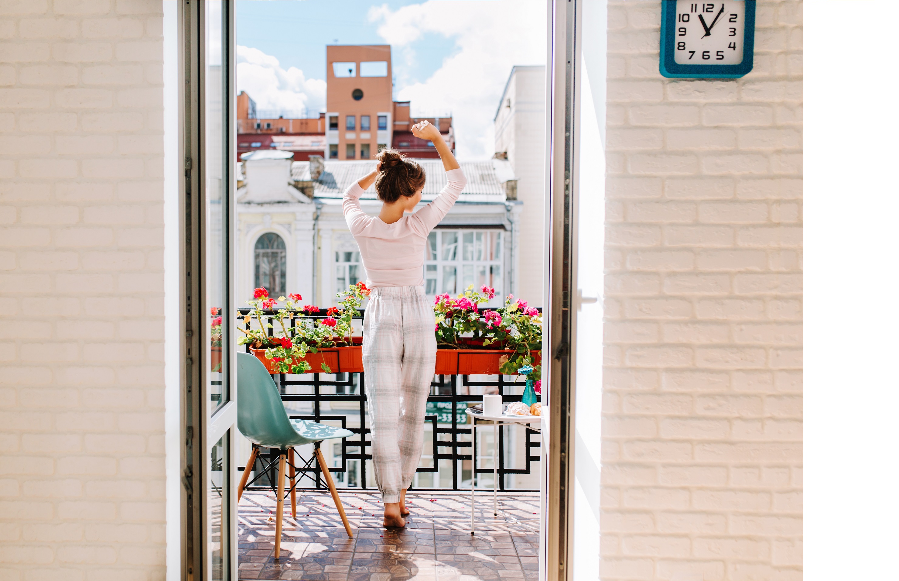 Die Frau auf dem Balkon in der offenen Balkontür